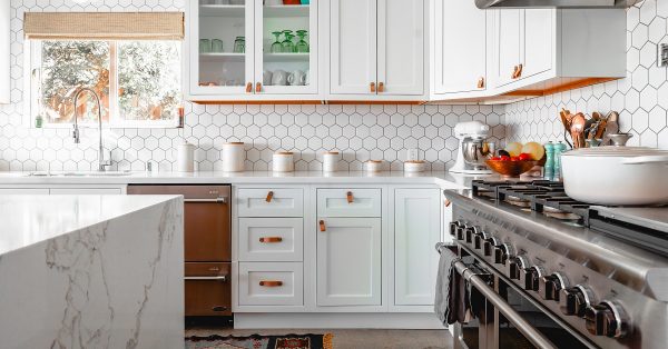 White kitchen with hexagon tile backsplash.